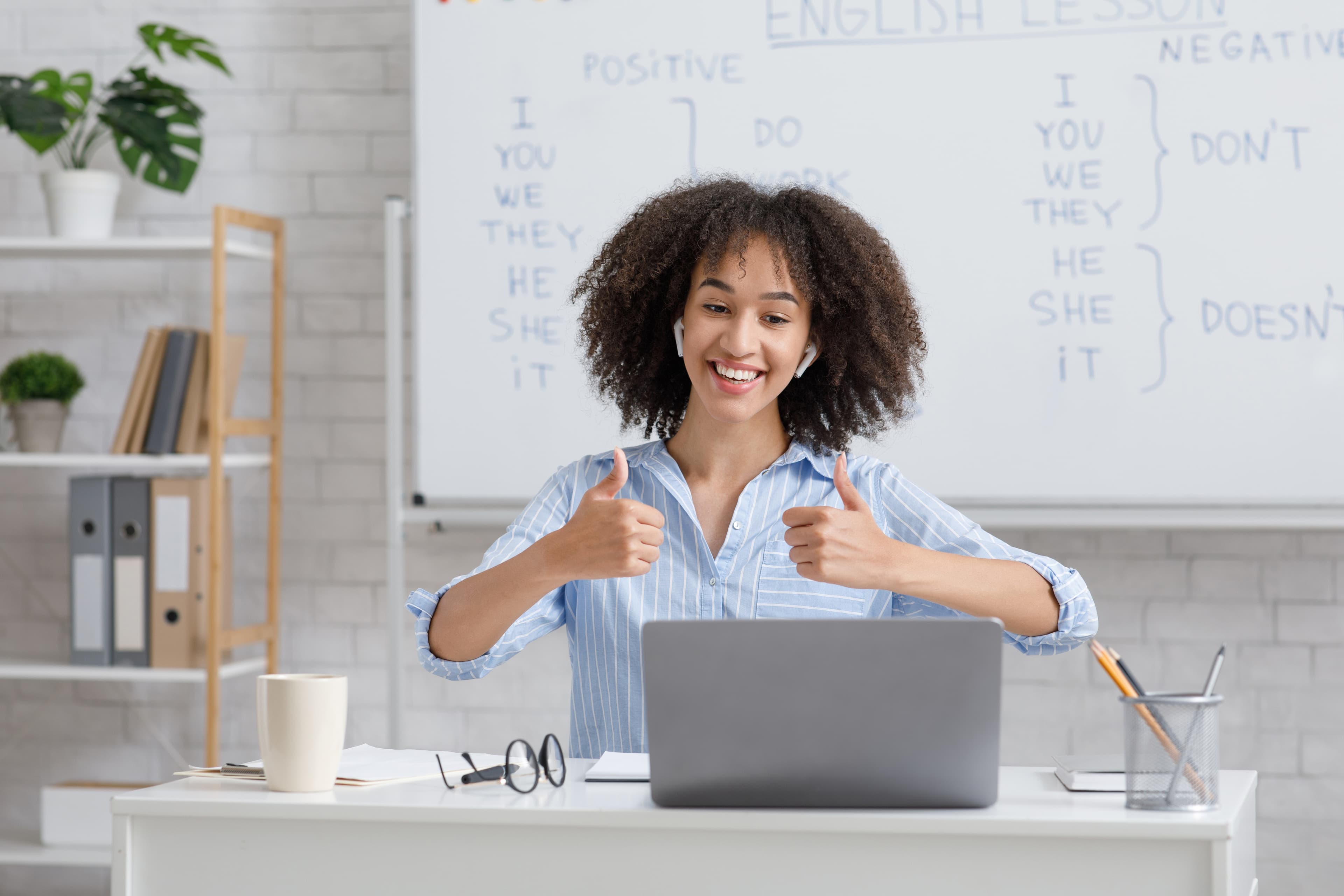 Taaltrainer geeft uitleg bij een whiteboard met Engelse grammatica