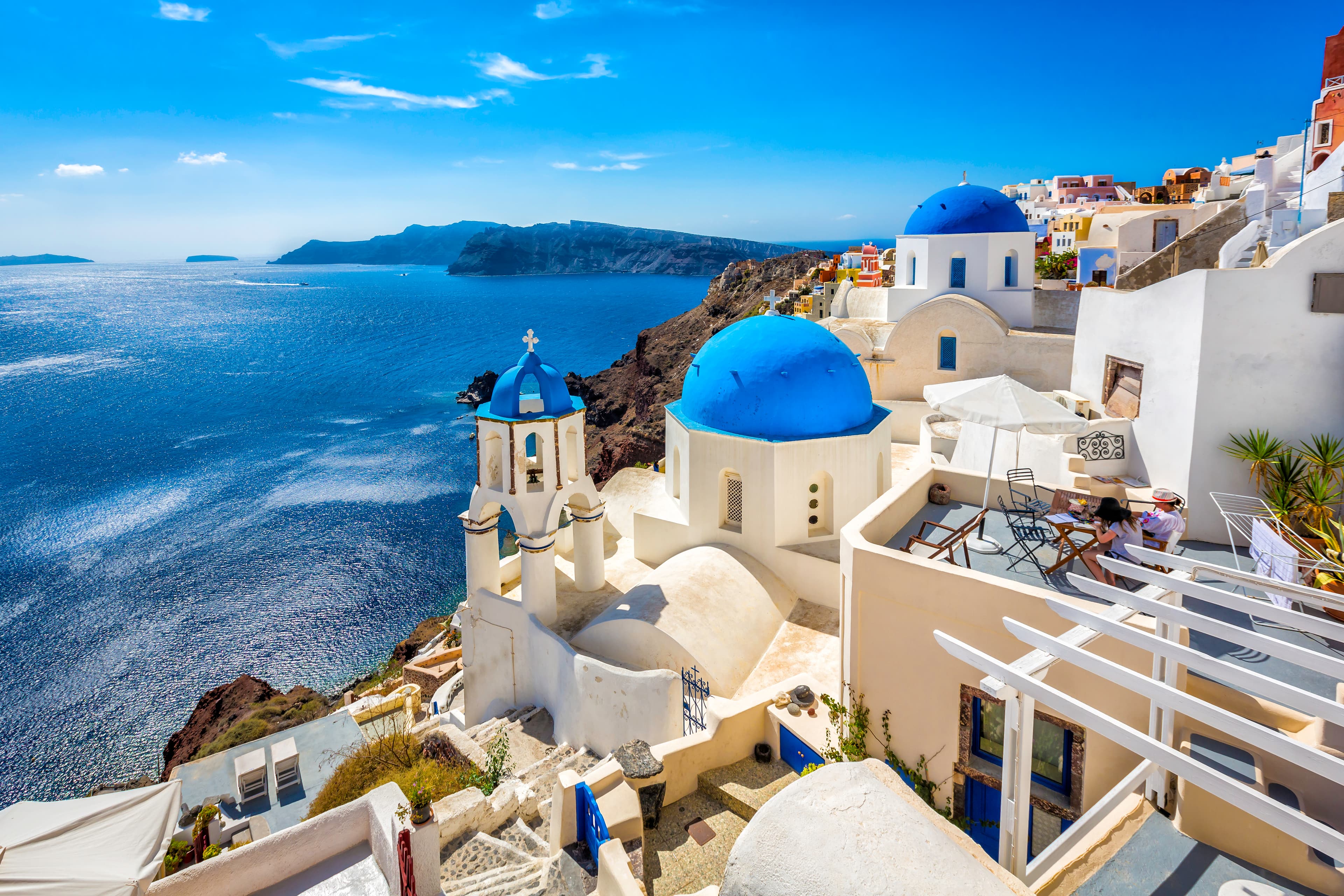 Blauwe koepels van Santorini aan zee